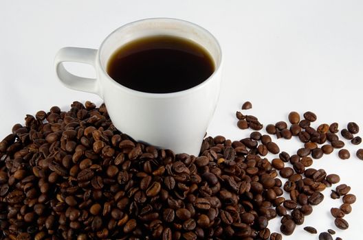 White cup with coffee and trowel of coffee beans