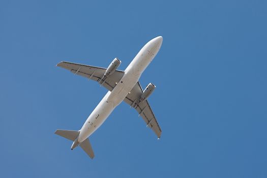 Airplane flying away to the blue sky