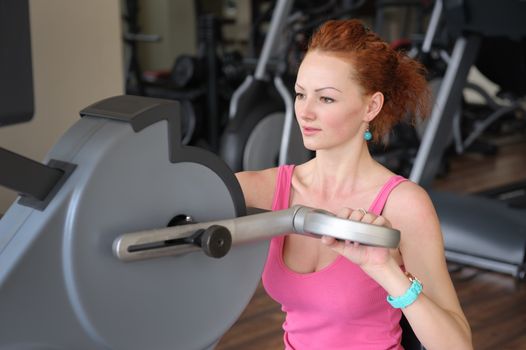 young red haired girl doing hands spinning machine workout