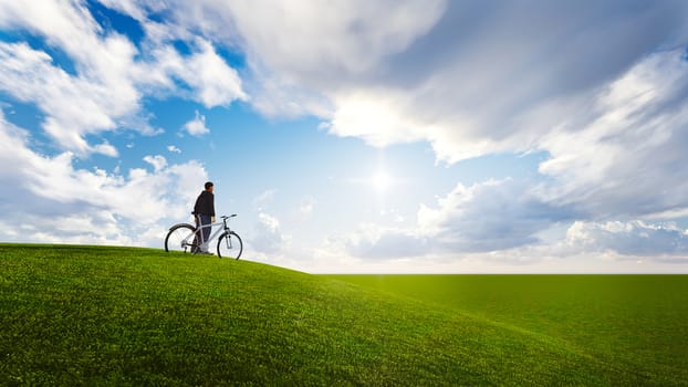 man and bike in a meadow with blue sky