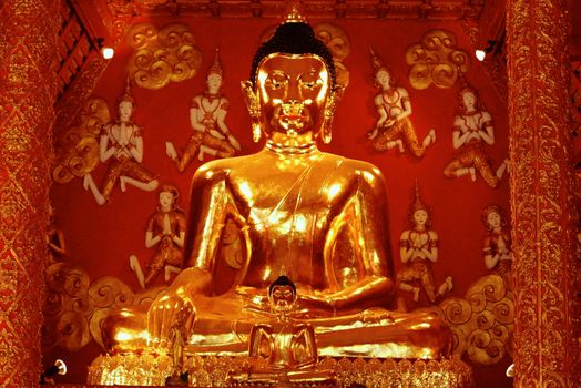 big buddha image that made by real gold at temple hall surrounding with angels,Lampang,Thailand