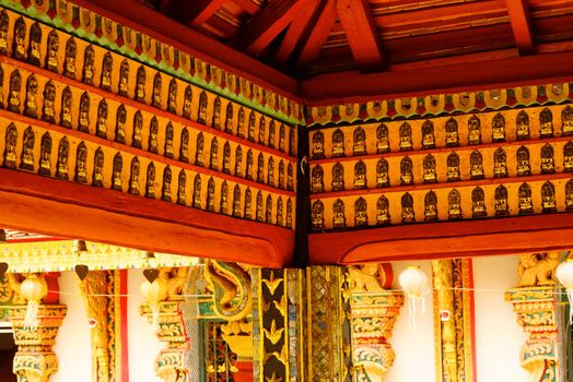 the detail of ancient thai decorated pattern that include handcraft wood carving work,gold painting and decorated with gold plate,mirror and precious stone,Lampang temple,Thailand