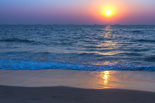 Scenic view from sand beach in Goa to beautiful sunset above the Arabian sea. Sun reflection on sea surface