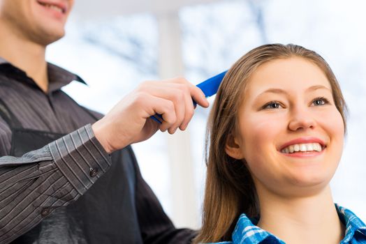 male hairdresser puts woman's hair in a hairdressing salon