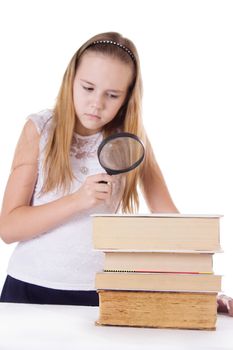 Little girl reading with loupe isolated on white, focus on books