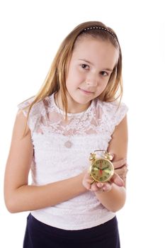 Schoolgirl holding small alarm clock on a white background, focus on girl