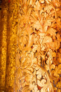 the detail of ancient thai decorated pattern that include handcraft wood carving work,gold painting and decorated with gold plate,mirror and precious stone,Lampang temple,Thailand