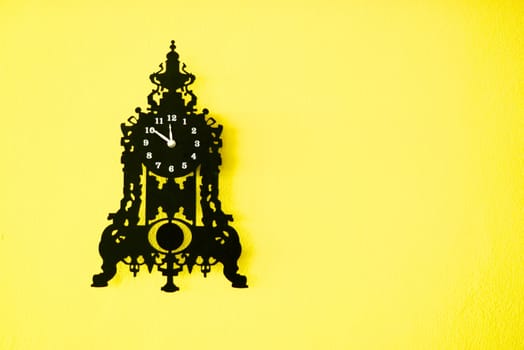black wall clock on yellow wall