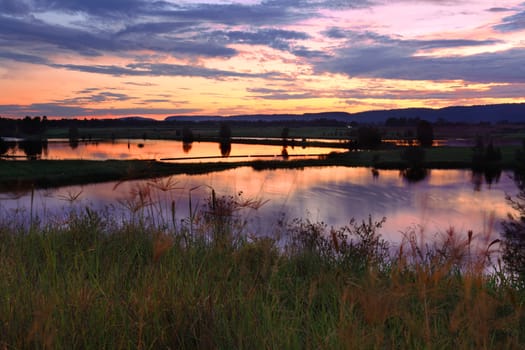 Sunset across some of the lakes at Penrith with Blue Mountains in the background. Long 8sec exposure  motion in some moving plants