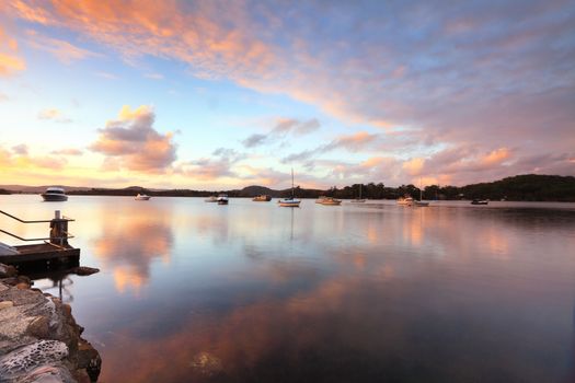 Sunset at Bensville Australia.   Boats and yachts and cloud reflections in the late afternoon.