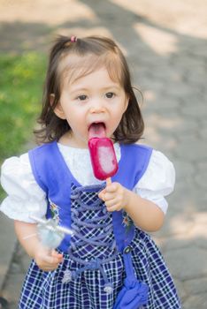 Adorable little cute girl eating icecream while holding wand