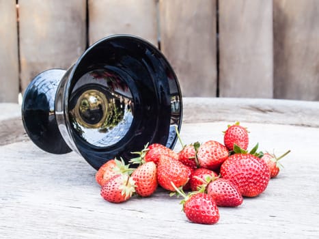 strawberries in black bowl on wood background