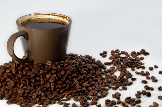 Brown cup with coffee and trowel of coffee beans