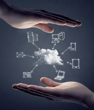 Hand drawn technology and computer icons around cloud with hands on gray background, cloud computing concept.