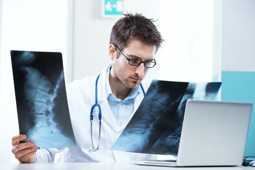 Professional radiologist examining an X-ray image of human spine.
