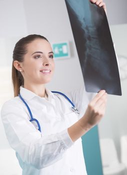 Female doctor checking xray image and smiling