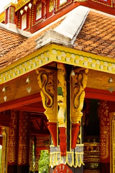 the detail of ancient thai corbel pattern that include handcraft wood carving work,gold painting and decorated with gold plate,mirror and precious stone,Lampang temple,Thailand