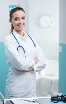 Portrait of a smiling female doctor standing with arms folded 