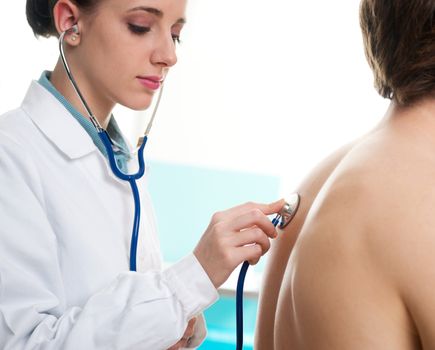 Female doctor listening man's back through stethoscope 