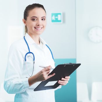 Young woman doctor or pharmacist in office with clipboard