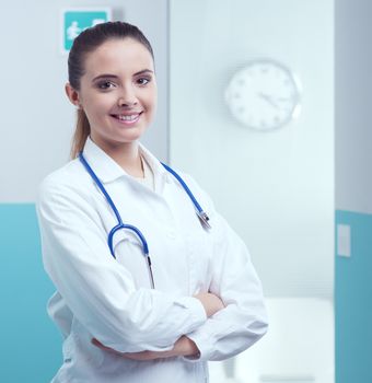 Portrait of a smiling female doctor standing with arms folded 