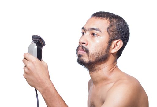 Asian man seriously hold hair clipper before cutting his hair by himself