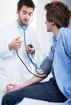 Doctor measuring blood pressure with specific medical equipment.