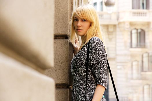 A young adult woman standing in front of a Store in downtown Barcelona, Spain.