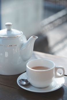 Teacup and teapot on the table at outdoors cafe