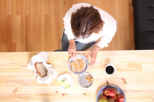 Portrait of a beautiful mature woman sitting in the kitchen. 