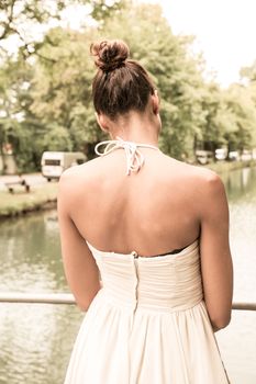 A young girl standing on a bridge.