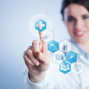 Young female doctor using a touch screen interface.