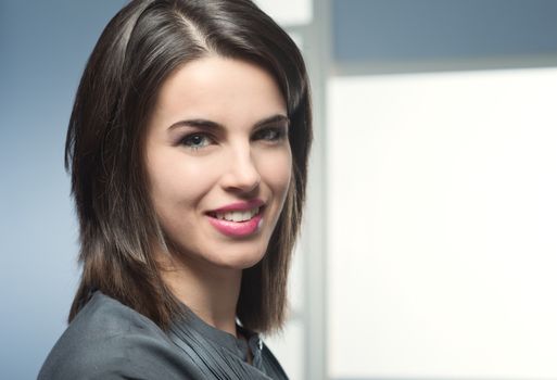 Beautiful blue eyed woman smiling and looking at camera.