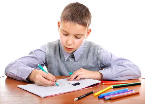 Cute Kid Drawing at the School Desk Isolated on the White Background