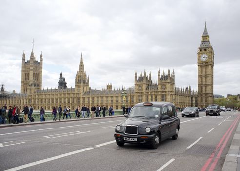 LONDON, UK – APRIL 18, 2014: Black taxi cab in front of the Palace of Westminster.