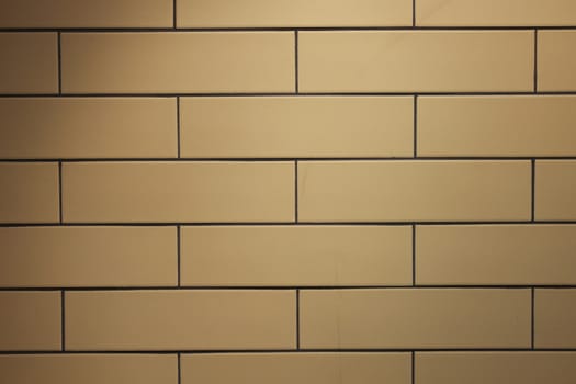 yellow brick wall with a smooth black seam