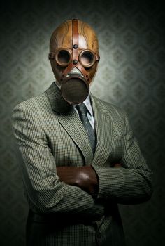Vintage businessman wearing a gas mask with retro wallpaper on background.