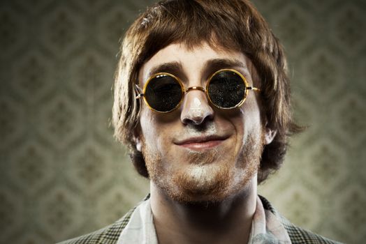 Funny 1960s style guy after snorting cocaine on vintage wallpaper background.