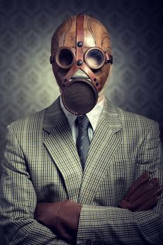 Vintage businessman wearing a gas mask with retro wallpaper on background.