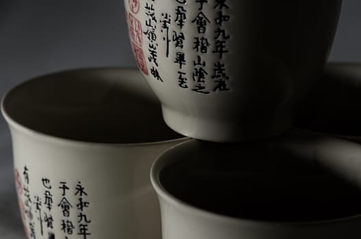 Three cups with chenese symbols, black background