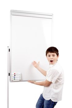 surprised young boy student in a classroom showing on a empty whiteboard