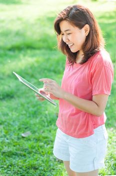 Happy Young Asian Woman Holding Digital Tablet and Smiling