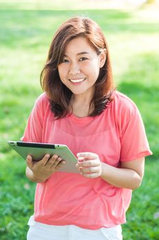 Happy Young Asian Woman Holding Digital Tablet and Smiling