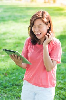Happy Young Asian Woman Holding Digital Tablet and Smiling