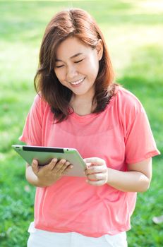 Happy Young Asian Woman Holding Digital Tablet and Smiling