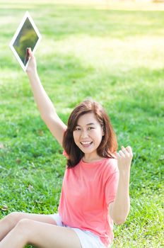 Happy Young Asian Woman Holding Digital Tablet and Smiling