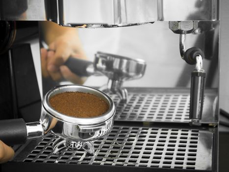 Barista holding portafilter with ground coffee