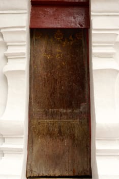 ancient wooden door that have very fine detail of thai pattern,shallow focus,Lampang temple,Thailand