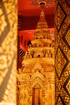 the high detail of square hall with pyramidal roof that made by real gold plate and decorated by craving thai pattern,Lampang temple,Thailand