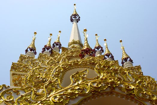  complicated stucco work showing of traditional thai pattern that decorated with mirror and precious stone at temple entrance gate ,Lampang temple,Thailand